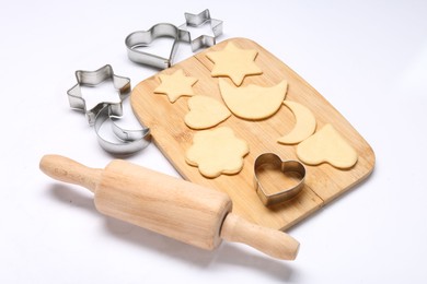 Raw dough, wooden rolling pin and cookie cutters isolated on white