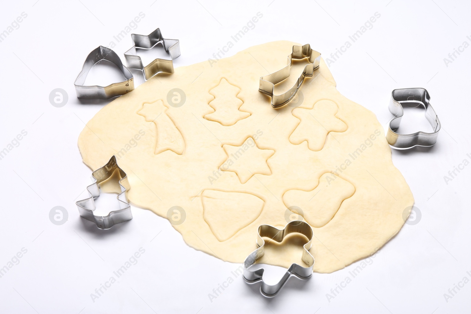 Photo of Raw dough and cookie cutters isolated on white