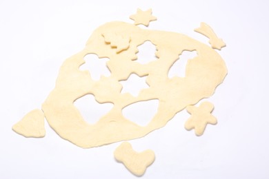 Photo of Raw dough and uncooked cookies in different shapes isolated on white