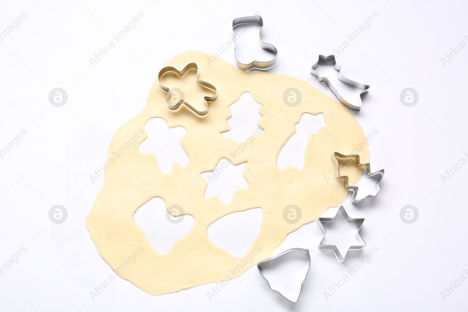 Photo of Raw dough and cookie cutters isolated on white, top view