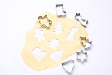 Photo of Raw dough and cookie cutters isolated on white, top view