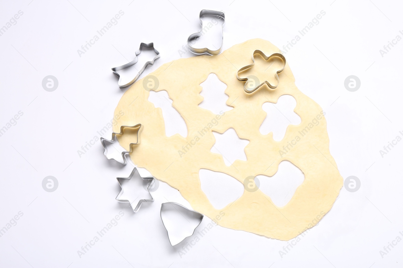 Photo of Raw dough and cookie cutters isolated on white, top view