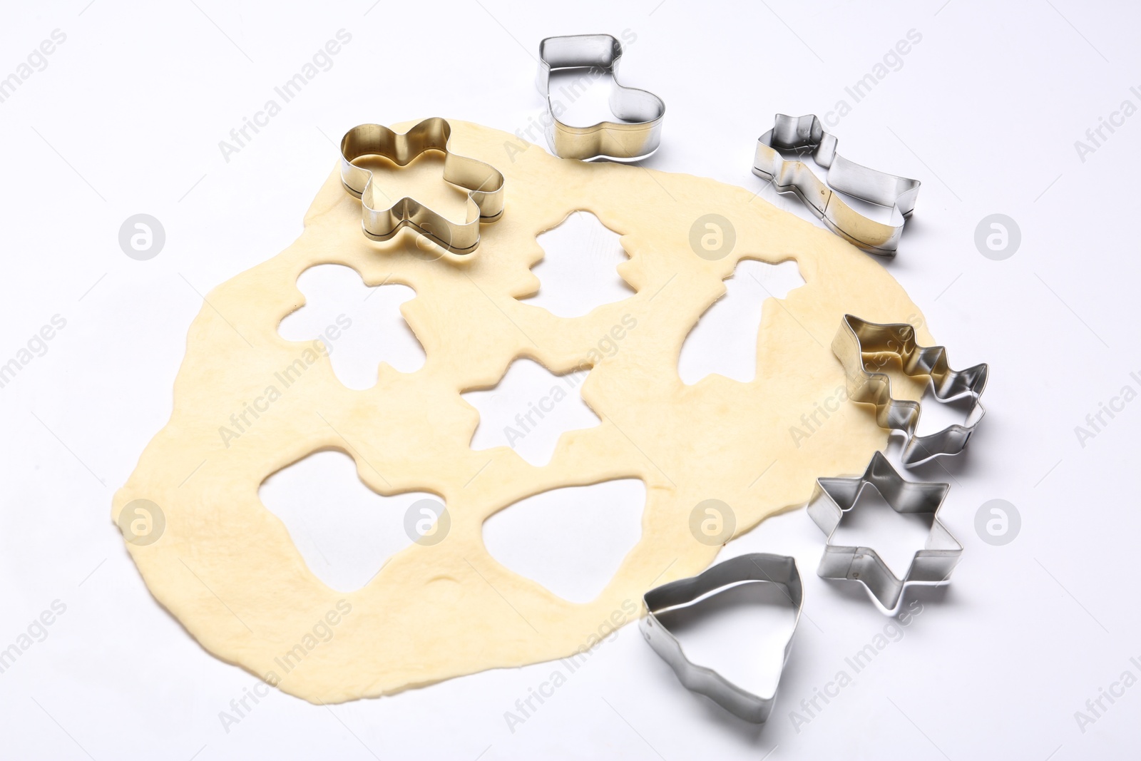 Photo of Raw dough and cookie cutters isolated on white