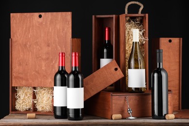 Different bottles of wine, wooden boxes, corks and corkscrew on table