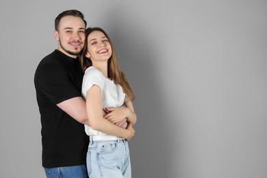 Photo of Happy couple hugging on grey background. Space for text