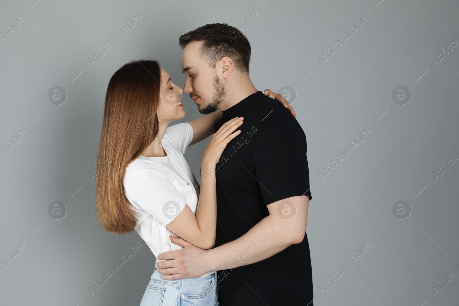 Photo of Cute couple hugging on grey background. Strong relationship