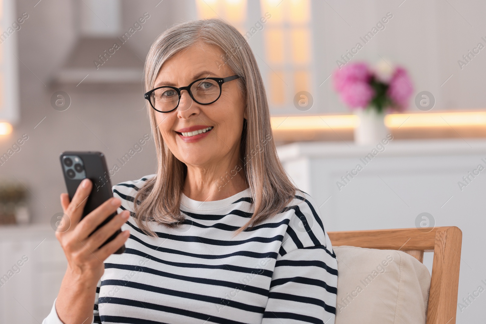 Photo of Senior woman using mobile phone at home