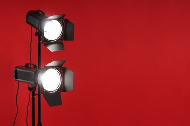 Photo of Red photo background and professional lighting equipment in studio, space for text