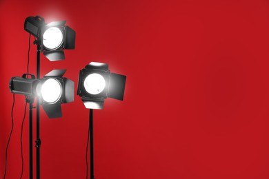 Photo of Red photo background and professional lighting equipment in studio, space for text