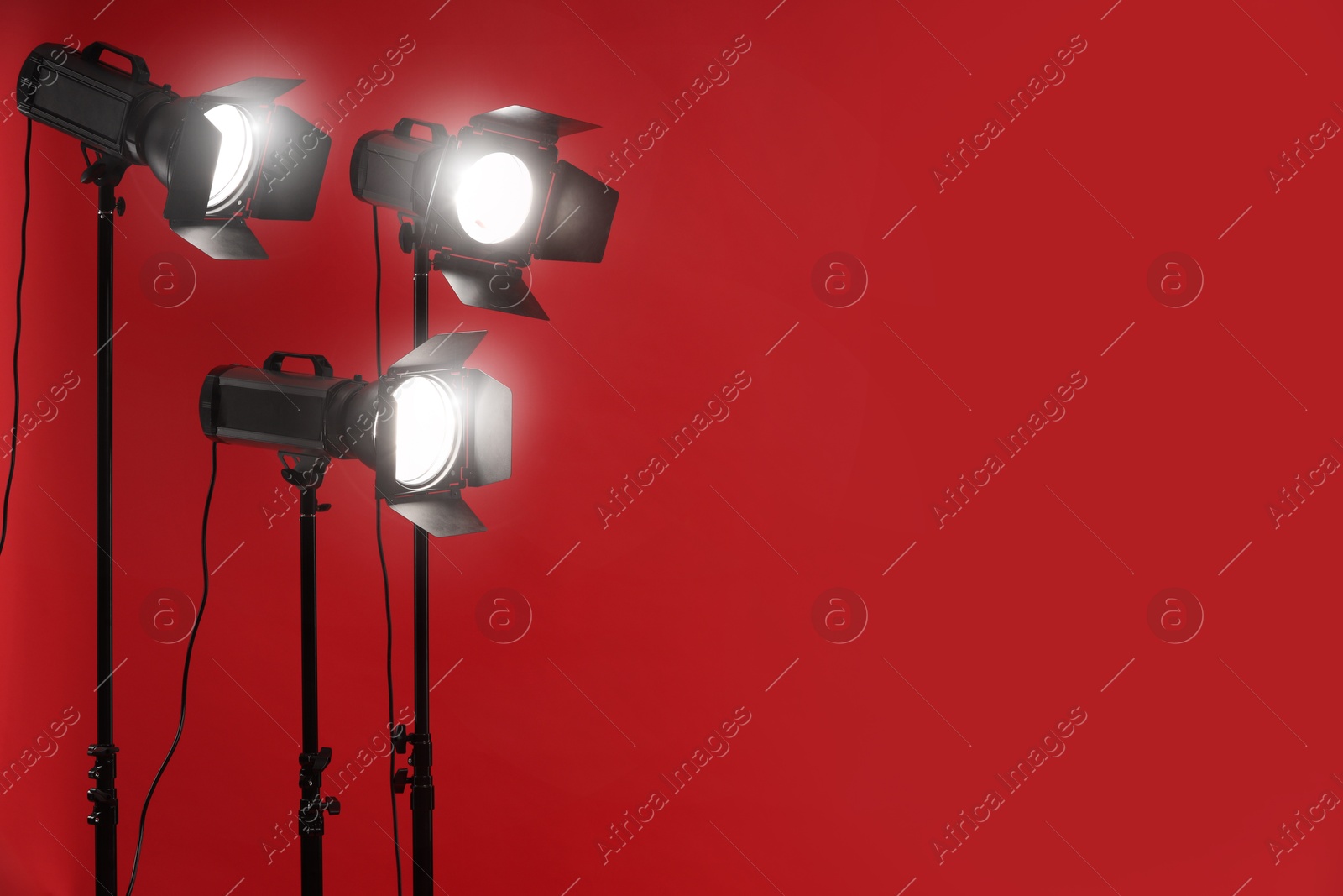 Photo of Red photo background and professional lighting equipment in studio, space for text