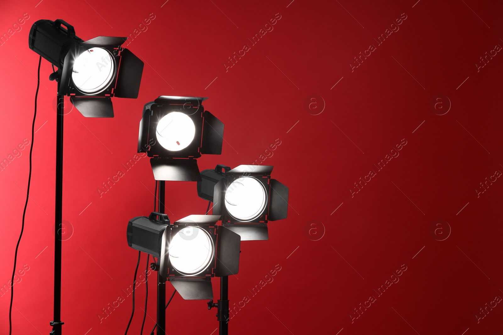 Photo of Red photo background and professional lighting equipment in studio, space for text