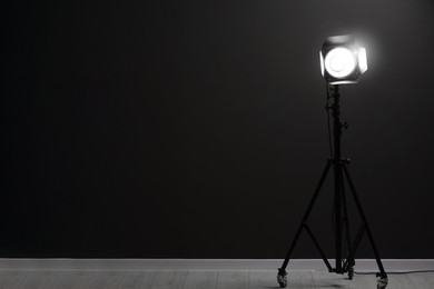 Photo of Dark photo background and professional lighting equipment in studio, space for text