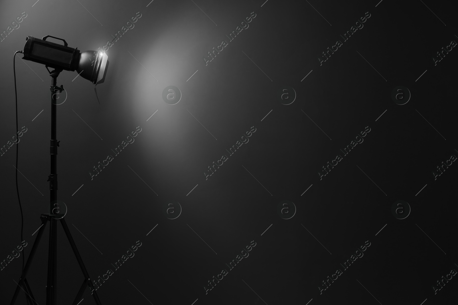 Photo of Dark photo background and professional lighting equipment in studio, space for text