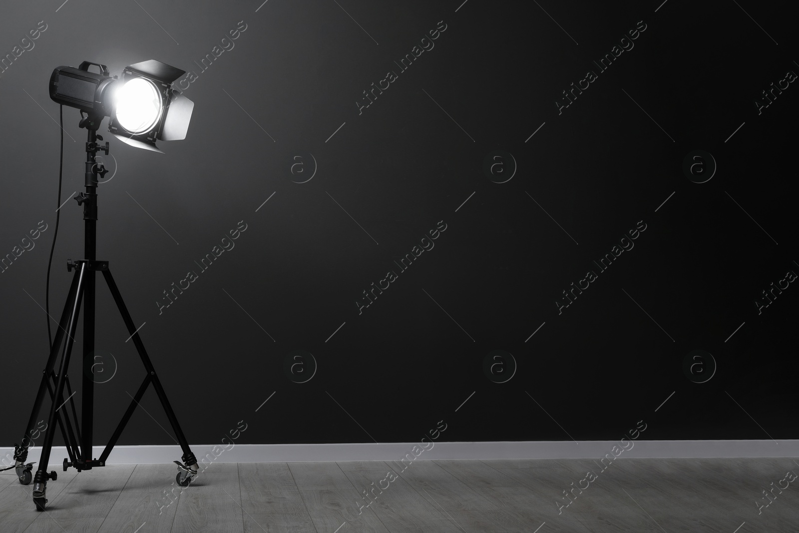 Photo of Dark photo background and professional lighting equipment in studio, space for text