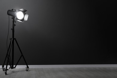 Dark photo background and professional lighting equipment in studio, space for text