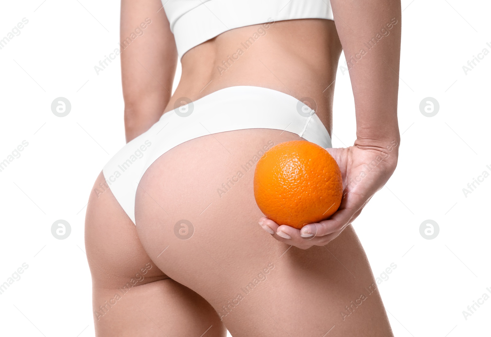 Photo of Woman in underwear with orange on white background, closeup. Cellulite problem