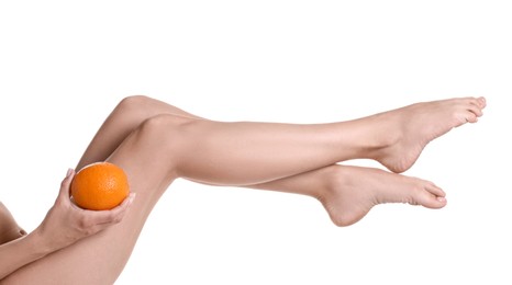 Photo of Woman with orange on white background, closeup. Cellulite problem