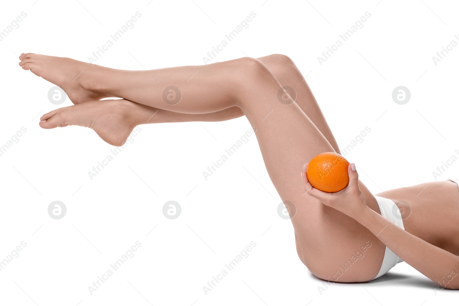 Photo of Woman in underwear with orange on white background, closeup. Cellulite problem