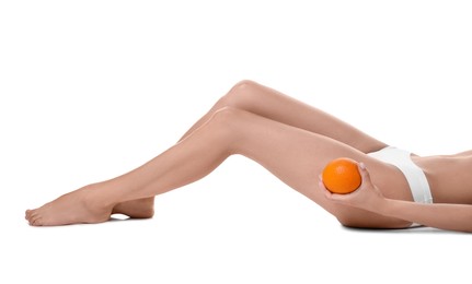 Woman in underwear with orange on white background, closeup. Cellulite problem