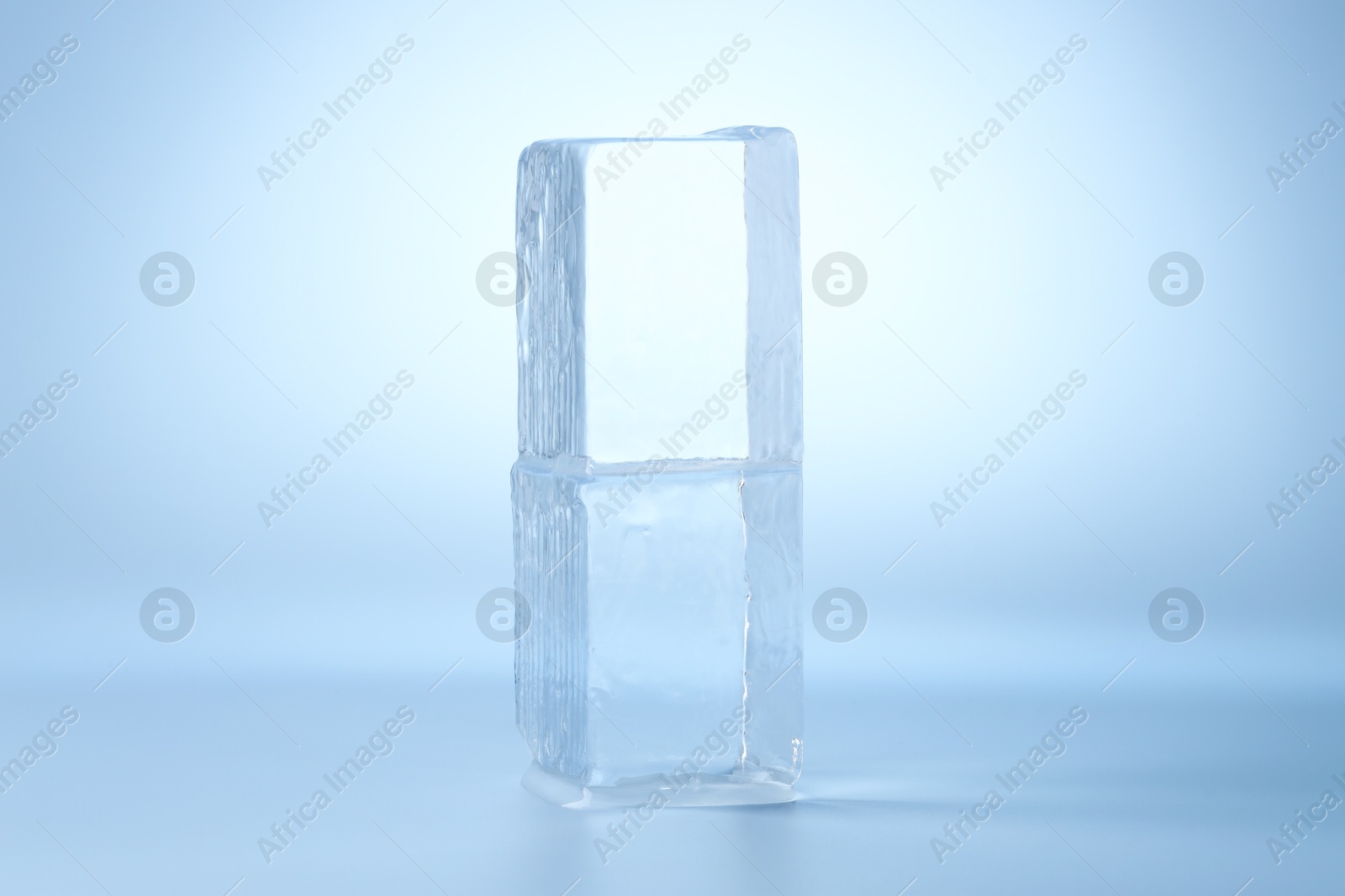 Photo of Blocks of clear ice on light blue background