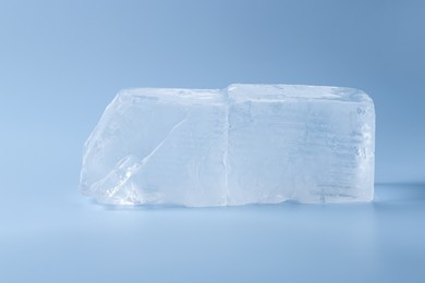 Photo of Blocks of clear ice on light blue background