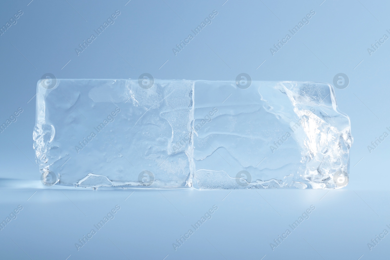 Photo of Blocks of clear ice on light blue background