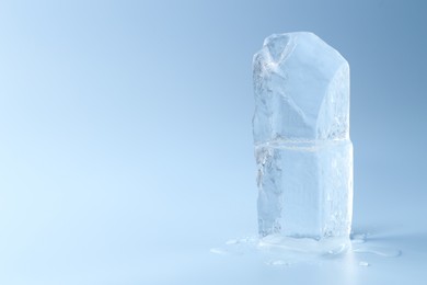 Photo of Blocks of clear ice on light blue background, space for text