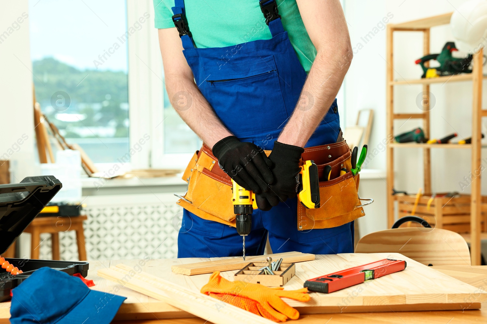 Photo of Craftsman working with drill at table in workshop, closeup