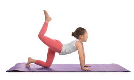 Cute little girl doing gymnastic exercise on white background