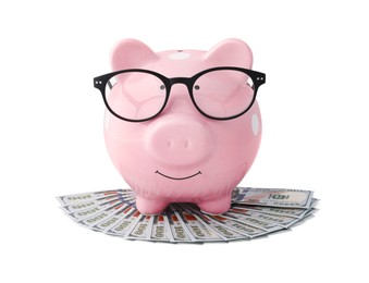 Photo of Pink piggy bank in glasses and money on white background