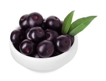 Photo of Fresh ripe acai berries in bowl and green leaves isolated on white