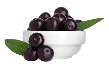 Fresh ripe acai berries in bowl and green leaves isolated on white