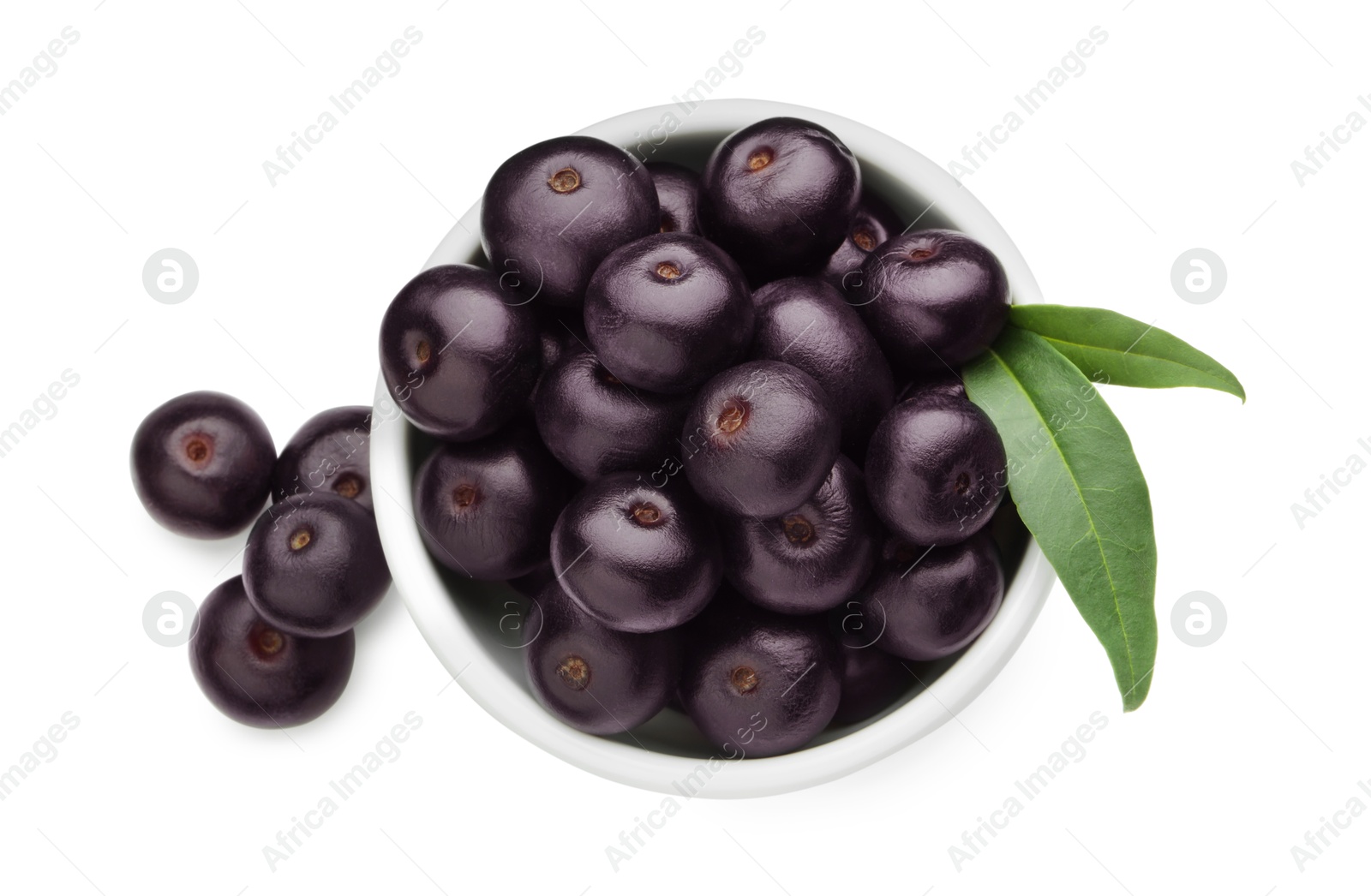 Photo of Fresh ripe acai berries in bowl and green leaves isolated on white, top view