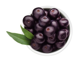 Photo of Fresh ripe acai berries in bowl and green leaves isolated on white, top view