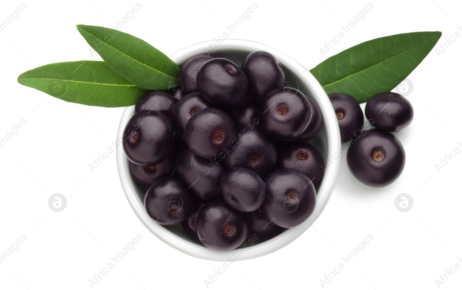 Photo of Fresh ripe acai berries in bowl and green leaves isolated on white, top view