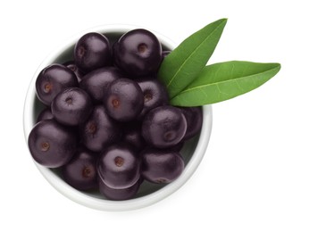 Fresh ripe acai berries in bowl and green leaves isolated on white, top view