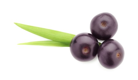 Photo of Fresh ripe acai berries and green leaves isolated on white, top view