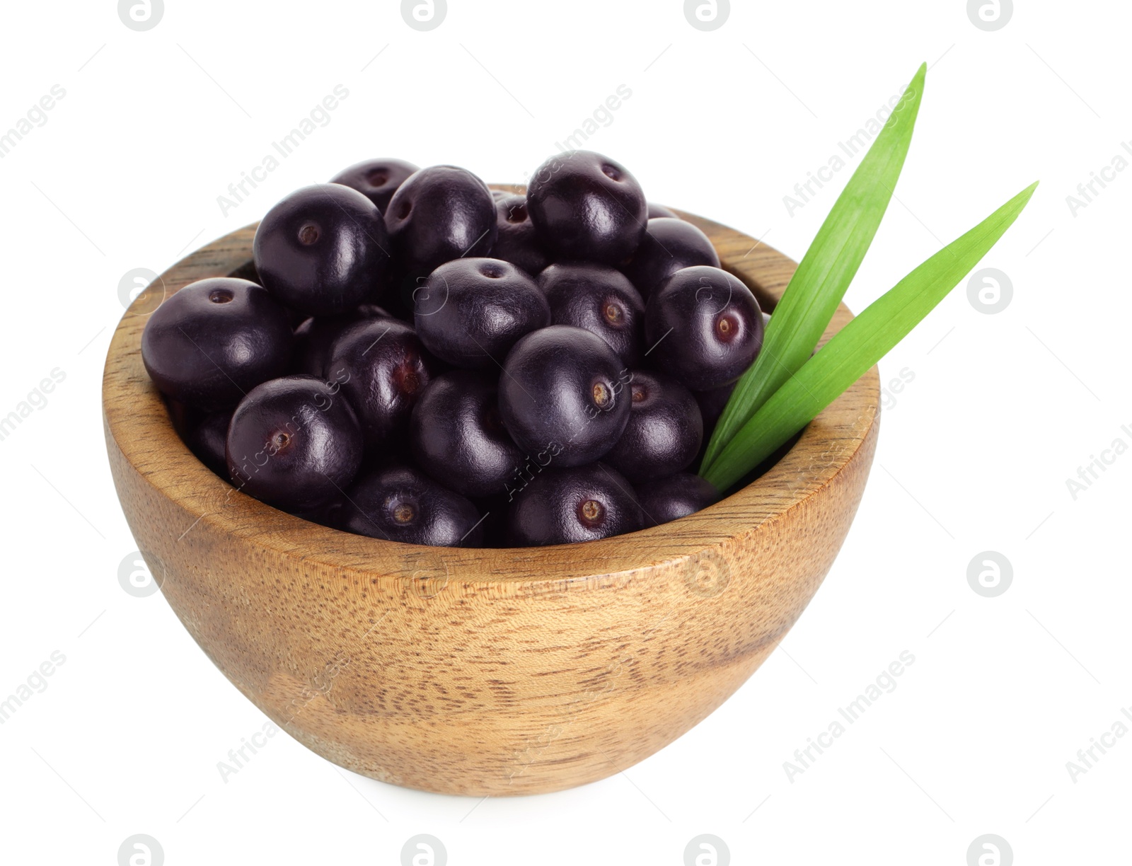 Photo of Fresh ripe acai berries in bowl and green leaves isolated on white