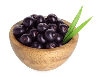 Fresh ripe acai berries in bowl and green leaves isolated on white