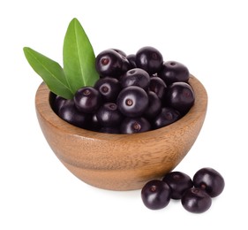 Photo of Fresh ripe acai berries in bowl and green leaves isolated on white