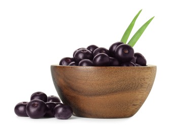 Photo of Fresh ripe acai berries in bowl and green leaves isolated on white