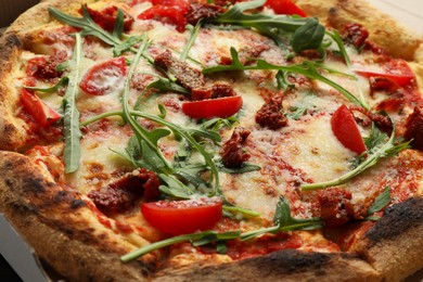 Tasty pizza with cheese, tomato and arugula on table, closeup