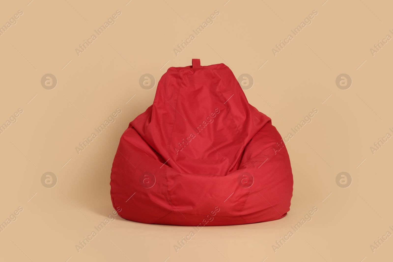 Photo of Red bean bag chair on beige background