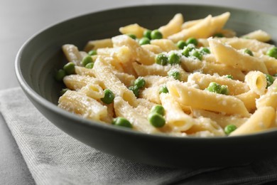 Delicious pasta with green peas and cheese on table, closeup