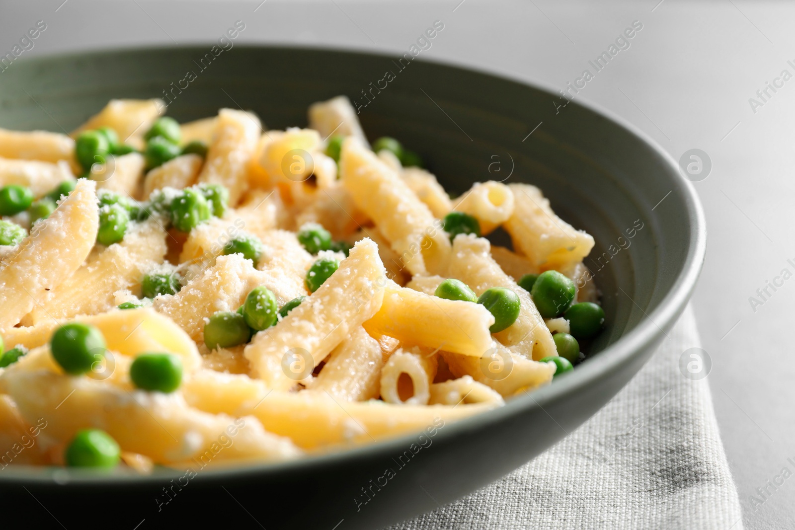 Photo of Delicious pasta with green peas and cheese on table, closeup