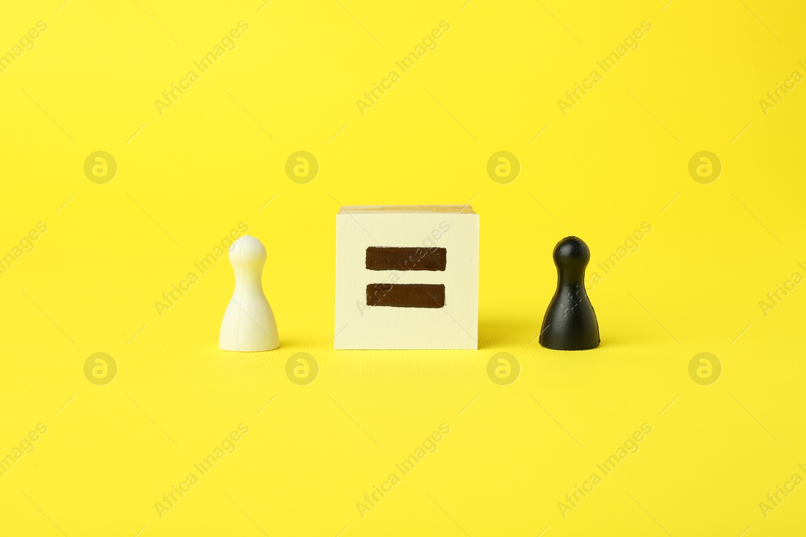 Photo of Game pieces of different colors and equal sign on yellow background