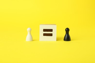 Game pieces of different colors and equal sign on yellow background