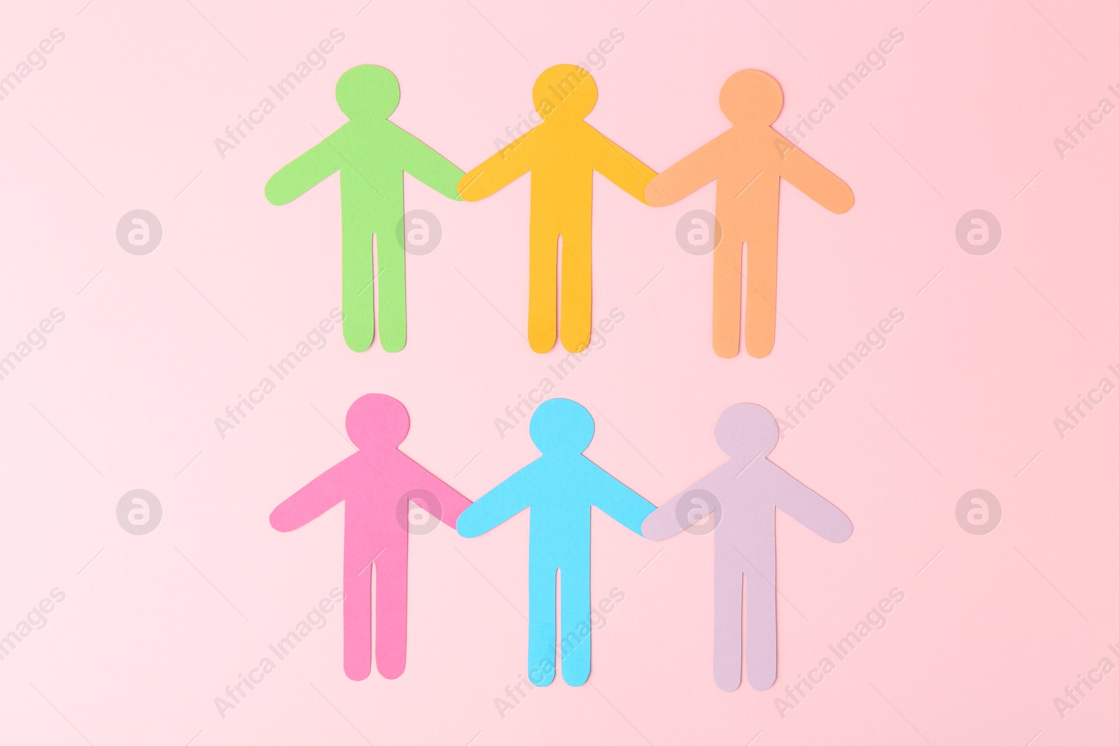 Photo of Equality concept. Paper human figures of different colors on pink background, top view