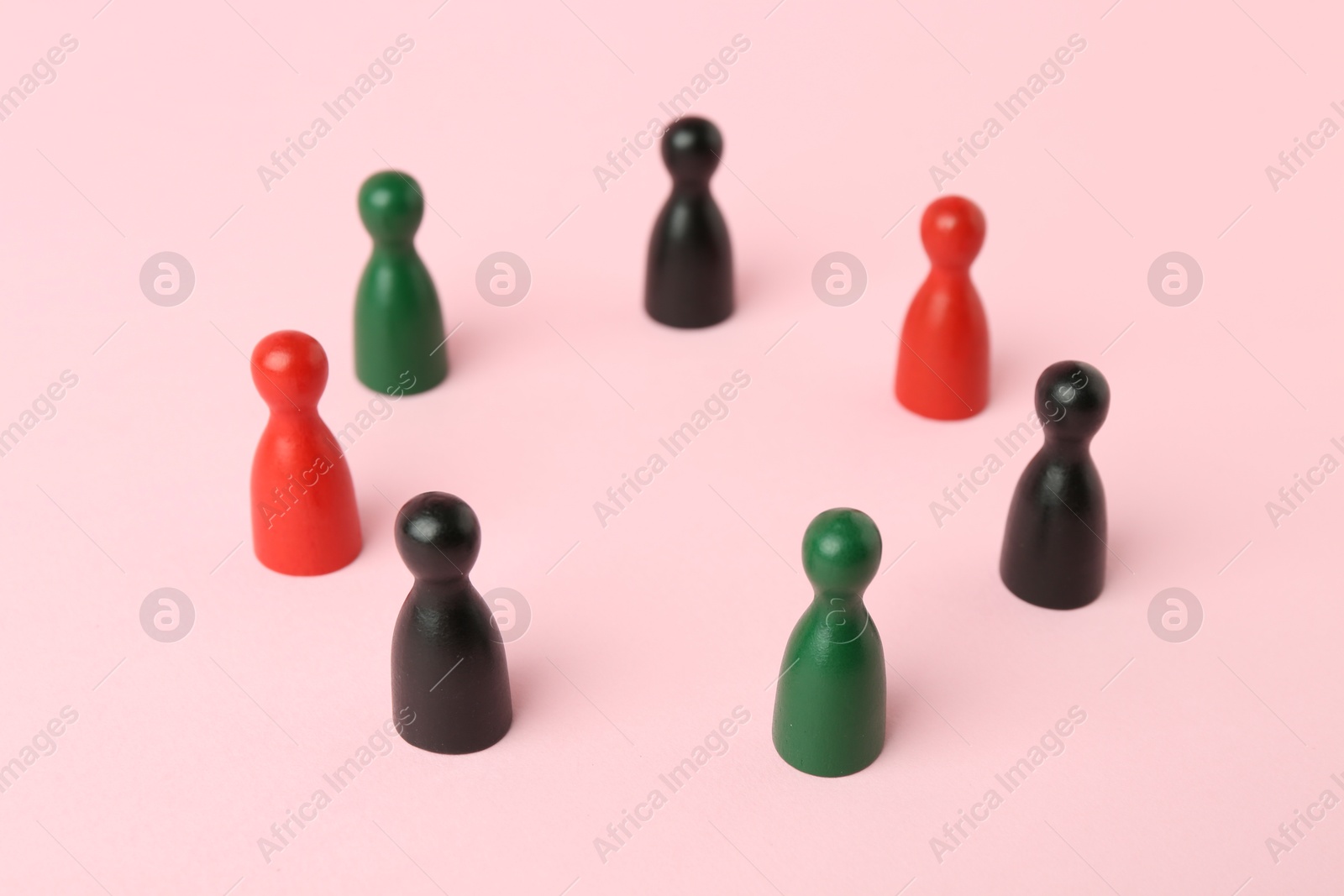 Photo of Equality concept. Game pieces of different colors on pink background