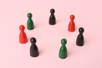 Equality concept. Game pieces of different colors on pink background